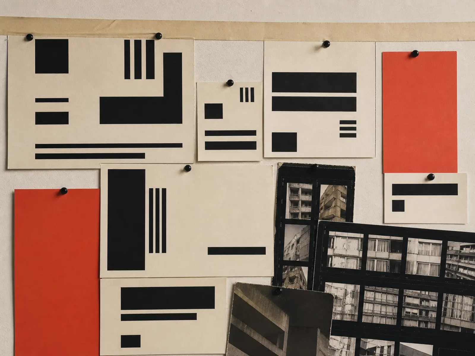 An art director's wall of pinned swatches, type specimens and printed contact sheets in the studio's palette.